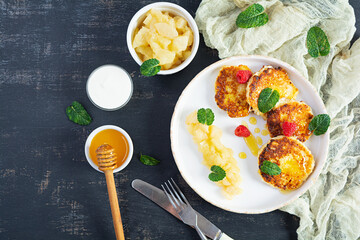Curd cheese pancake with sour cream, honey and berries. Delicious syrniki with caramelized pears. Top view
