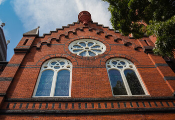Facade of a historic church with round windows on a brick wall. Victoria BC, Canada. July 23,2021