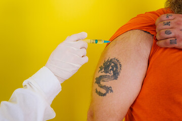 man with beard and tattoos does covid-19 vaccine