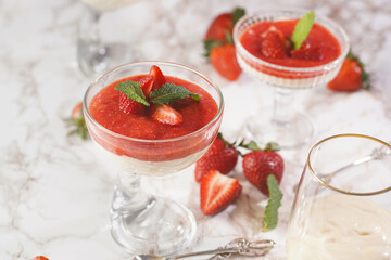Several glasses with traditional creamy pudding dessert panna cotta with peppermint and strawberry...