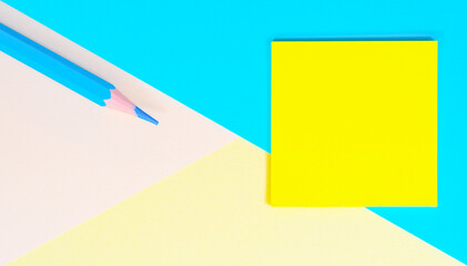 Education concept. Blank Multi colored paper geometric background with Blue pencil and yellow Green sheet