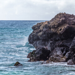 Surf splashes against volcanic rock.  Maui, Hawaii