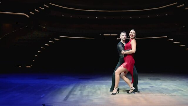 Ballroom couple on stage in blue tones. Elegant dancers, ballroom dancing on the stage of the theater.