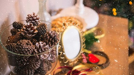 Animation of snow falling over pine cones and christmas decoration