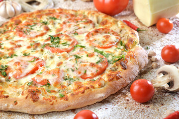 Delicious hot pizza with sliced meat and mushrooms served on wooden table with ingredients, close up view. Menu photo.