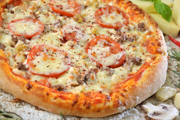 meat pizza with cheese tomato and mushrooms on wooden table with ingredients background.top view