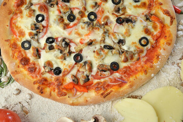 pizza with mushrooms olives and cheese. served on wooden table with ingredients.top view