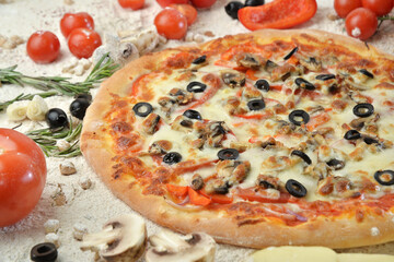 pizza with mushrooms olives and cheese. served on wooden table with ingredients.