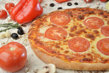 pizza with mushrooms tomato and cheese. served on wooden table with ingredients.