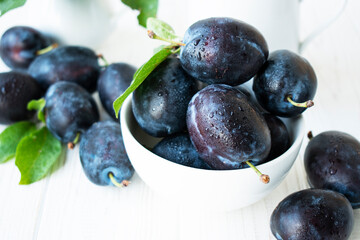 ripe sweet blue plums in a white plate
