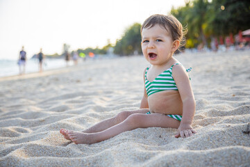 little girl yawns on the beach tired toddler yawns on the beach