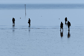 Silhouette von Menschen im Watt an der Nordsee