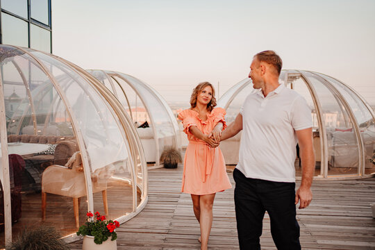 a man and a woman in love walk to a rooftop cafe on a date.