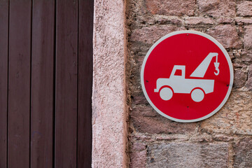 sign on the wall that says your vehicle can be towed
