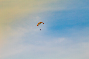 paraglider in the sky, extreme sport, paraglider flying at sunset  in the city of Florianópolis, Brasil