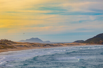extreme sport, paraglider flying at sunset at Praia dos Ingleses and Santinho, in the city of Florianópolis, Brasil