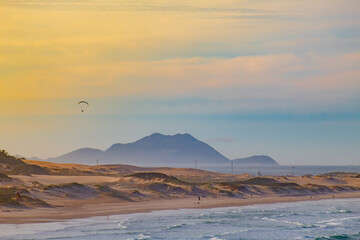 extreme sport, paraglider flying at sunset at Praia dos Ingleses and Santinho, in the city of Florian&oacute;polis, Brasil