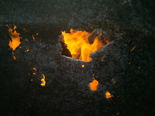building on fire close up. fiery fires. bright fire through a burnt hole. fires concept
