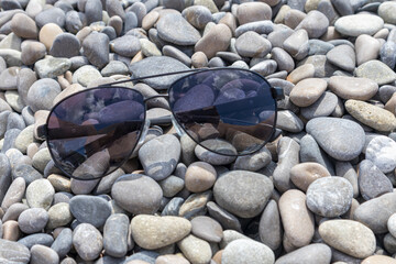 sunglasses on sea pebbles close-up as a background