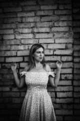 a girl with white hair against a brick wall black and white photo