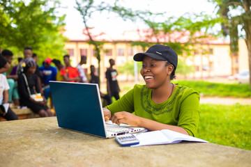 close up of a beautiful african lady studying in the school campus feeling excited © Vic Josh
