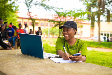 close up of a beautiful african lady studying in the school campus feeling excited