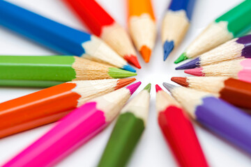 Naklejka premium Close up of the tips of coloured pencils arranged in a radial pattern with the leads pointing towards the centre, selective focus on the tip. back to school concept