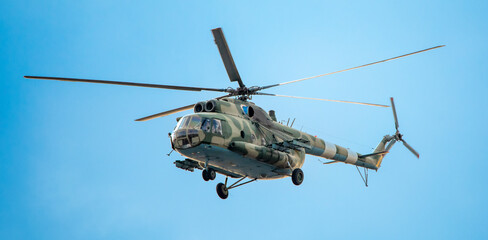 Military helicopter on a mission on a background of the sky.