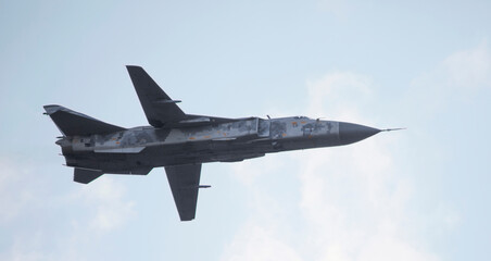Military fighter plane with variable sweep wing on sky background.