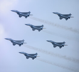 Five military fighter jets as part of a unit in the sky.