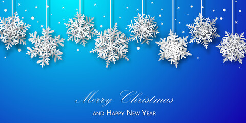 Christmas background of paper snowflakes with soft shadows, white on blue background