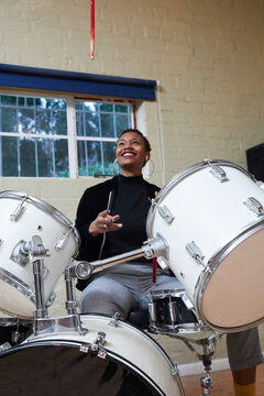 Black woman with short hair playing drums