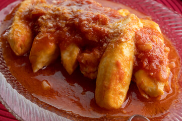 Quenelles from Lyon prepared with tomatoes, onion and aromatic herbs sauce