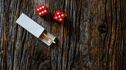 Two red dices with matches inside white matchbox