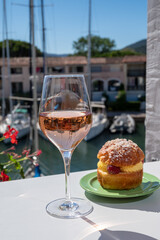 Tarte tropezienne or La Tarte de Saint-Tropez - dessert pastry consisting of filled brioche with cream and fresh berries.and glass of rose wine from Provence, France