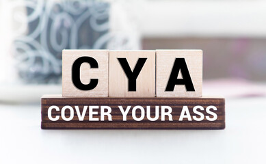 text cover your ass - CYA on wooden block, concept