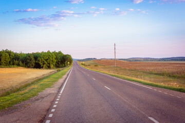 Road and beautiful sunset on the sky in autumn.