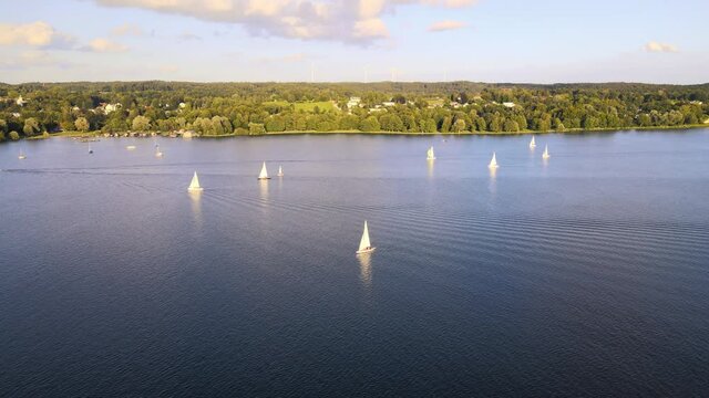 Sailboat on lake Starnberg. Munich residents and vacationers sail and relax on the idyllic mountain lake in Bavaria. Aerial view from drone