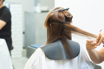 ヘアサロンで女性の髪の毛をカットするスタイリストの手元