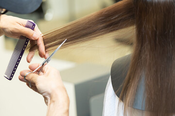 ヘアサロンで女性の髪の毛をカットするスタイリストの手元