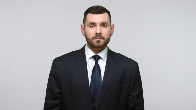 Portrait of young adult businessman wearing official style black suit standing with serious and bossy facial expression, confidence. Indoor studio shot isolated on gray background.