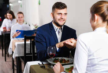 Romantic couple is having dinner in the restaurante indoor.