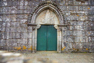 Fototapeta na wymiar Facade of the Medieval Pilgrim Church Santa Maria de Leboreiro with Closed Green Door on the Way of St James Pilgrimage Trail Camino de Santiago