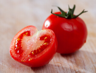 Image of cut fresh tomatoes on wooden table in home kitchen