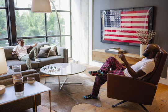 Father and son talking in living room