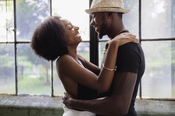 Young couple standing by window and embracing