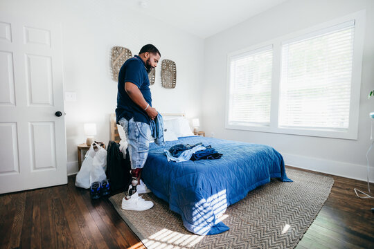 African American man with prosthetic leg doing chores, laundry, at home