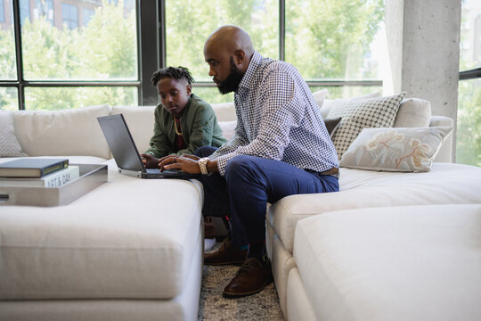 Father and son using laptop together