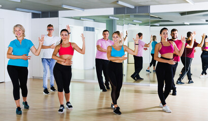 Fototapeta premium glad active adults of different ages dancing at dance class