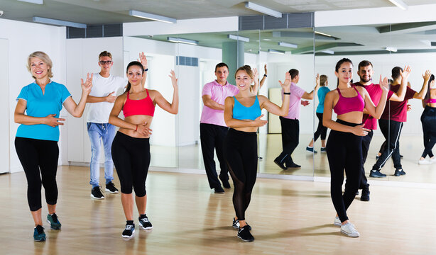 glad active adults of different ages dancing at dance class